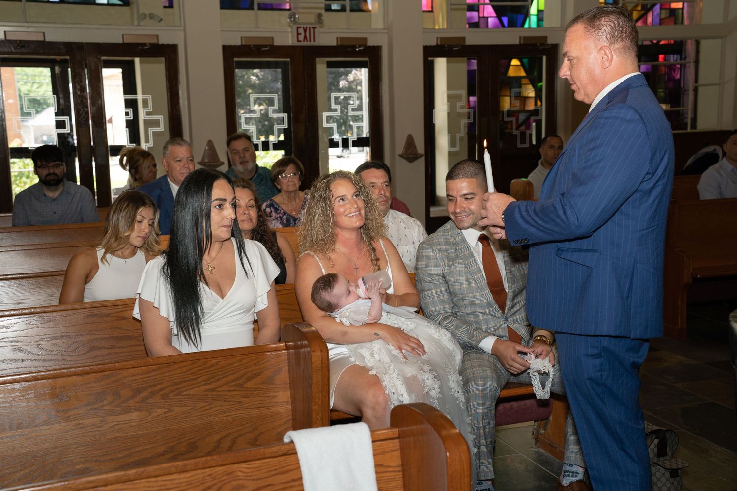 Candid moments during a baptism ceremony with family members around the baptismal font.