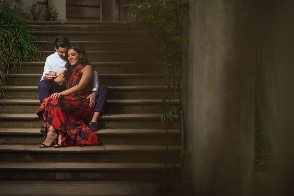 Intimate moment of couple sitting on stone steps in formal attire.