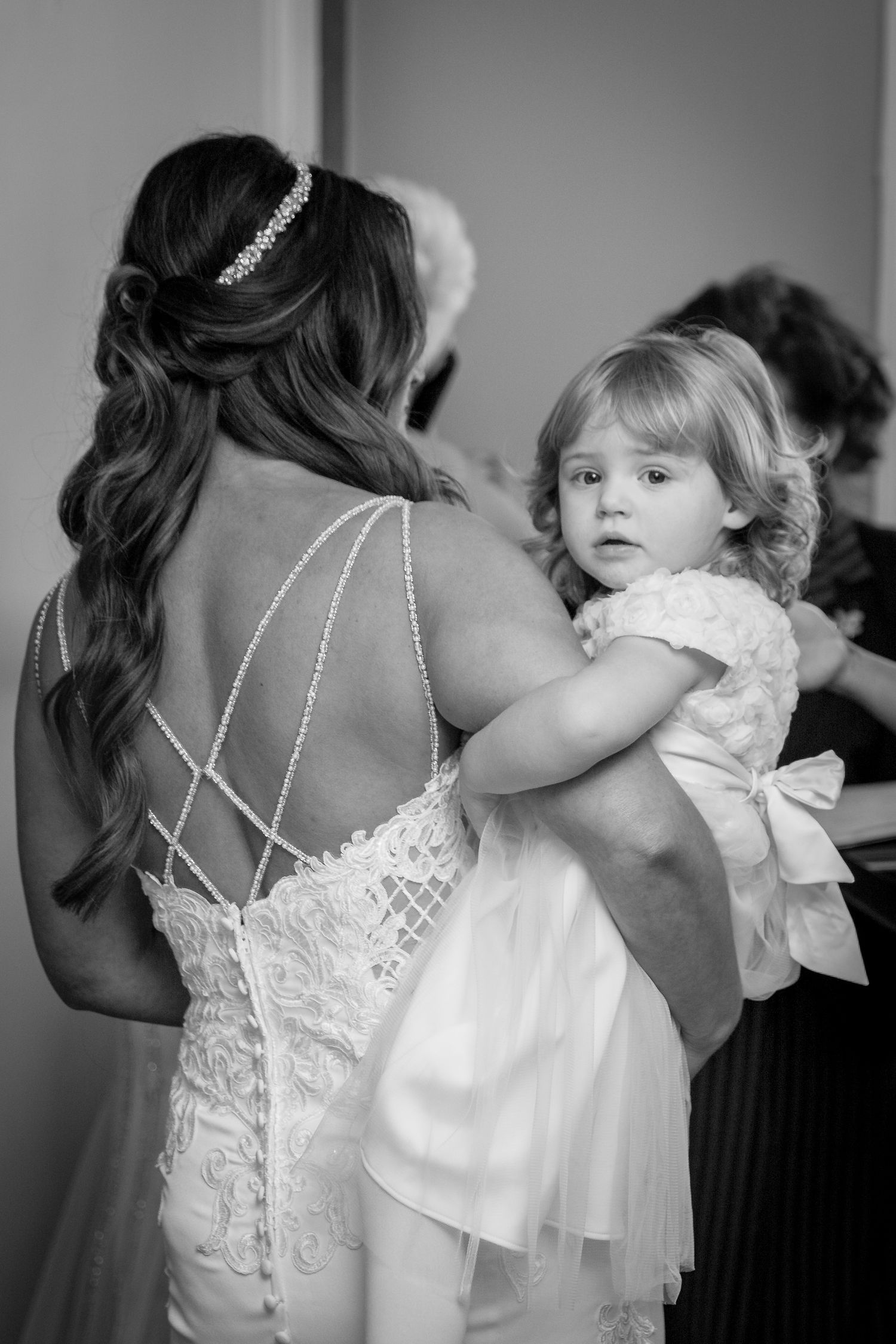 brides little girl in her arms turns to look over her shoulder at the camera taken at west tower ormskirk lancashire