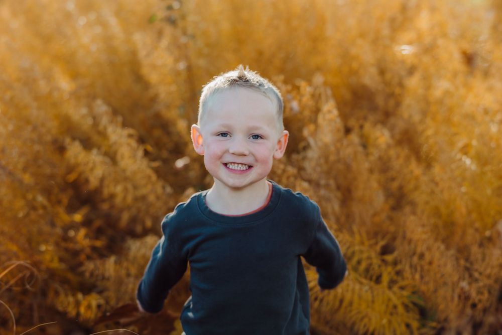 A joyful autumn portrait against golden grass.