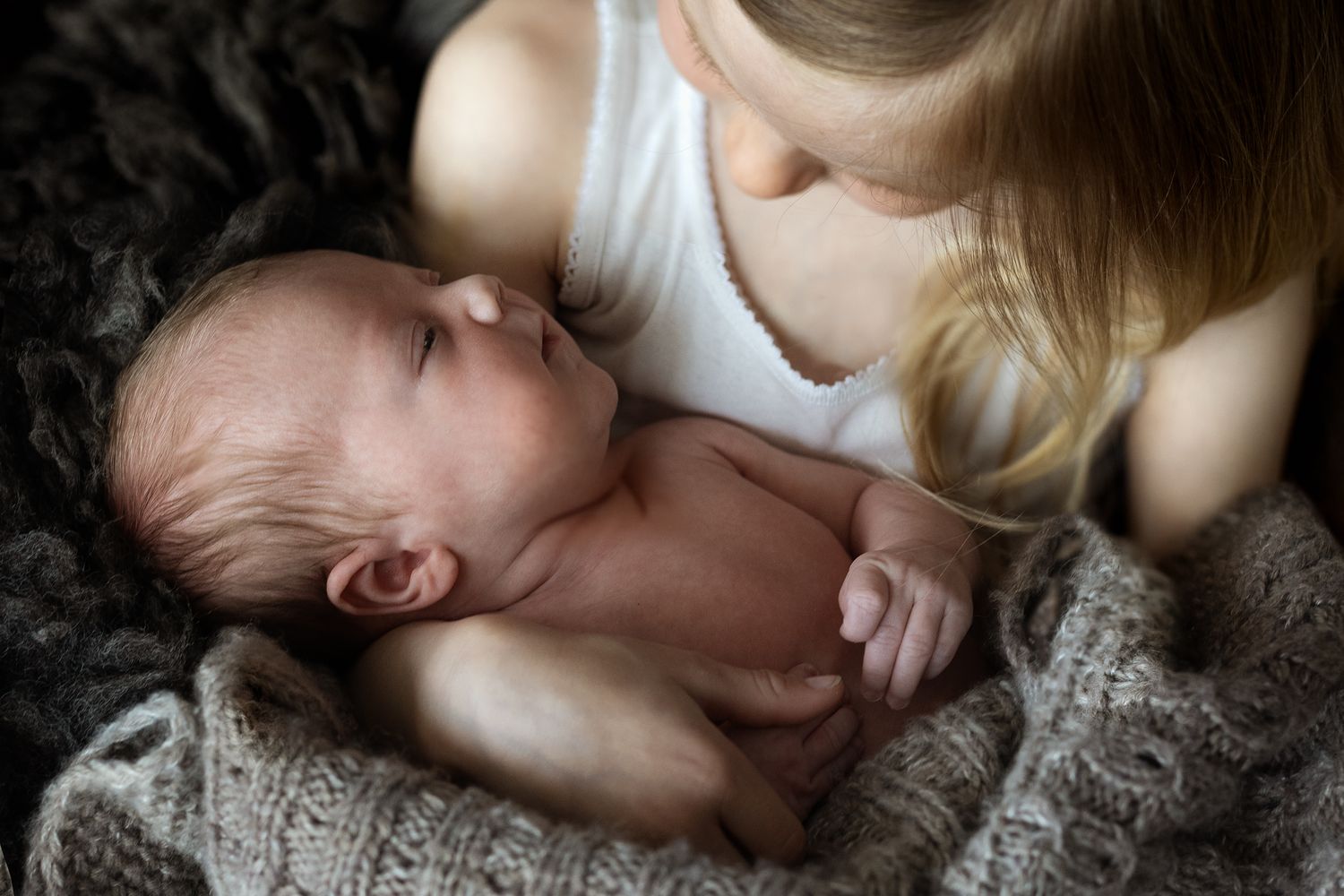 Series of tender moments between parent and sleeping infant.