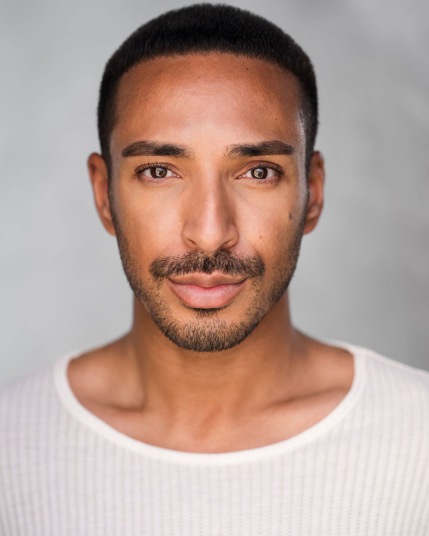 Professional headshot of person in black turtleneck against blurred background.