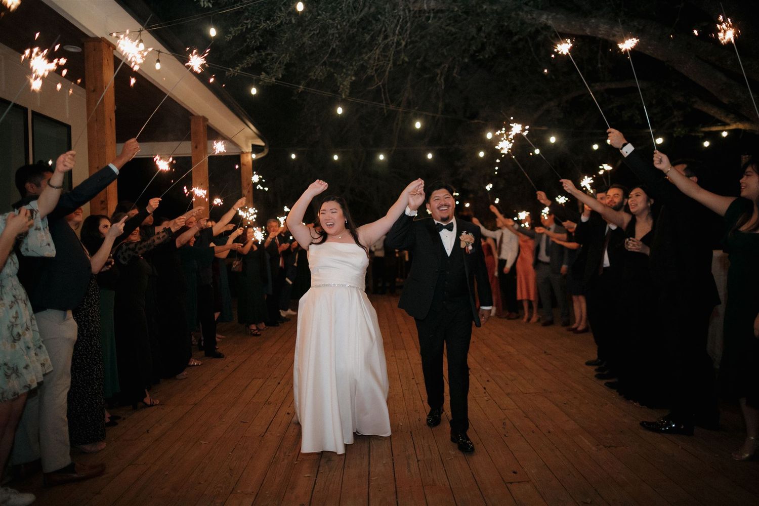 Newlyweds exit through a sparkler send-off line at their wedding reception.