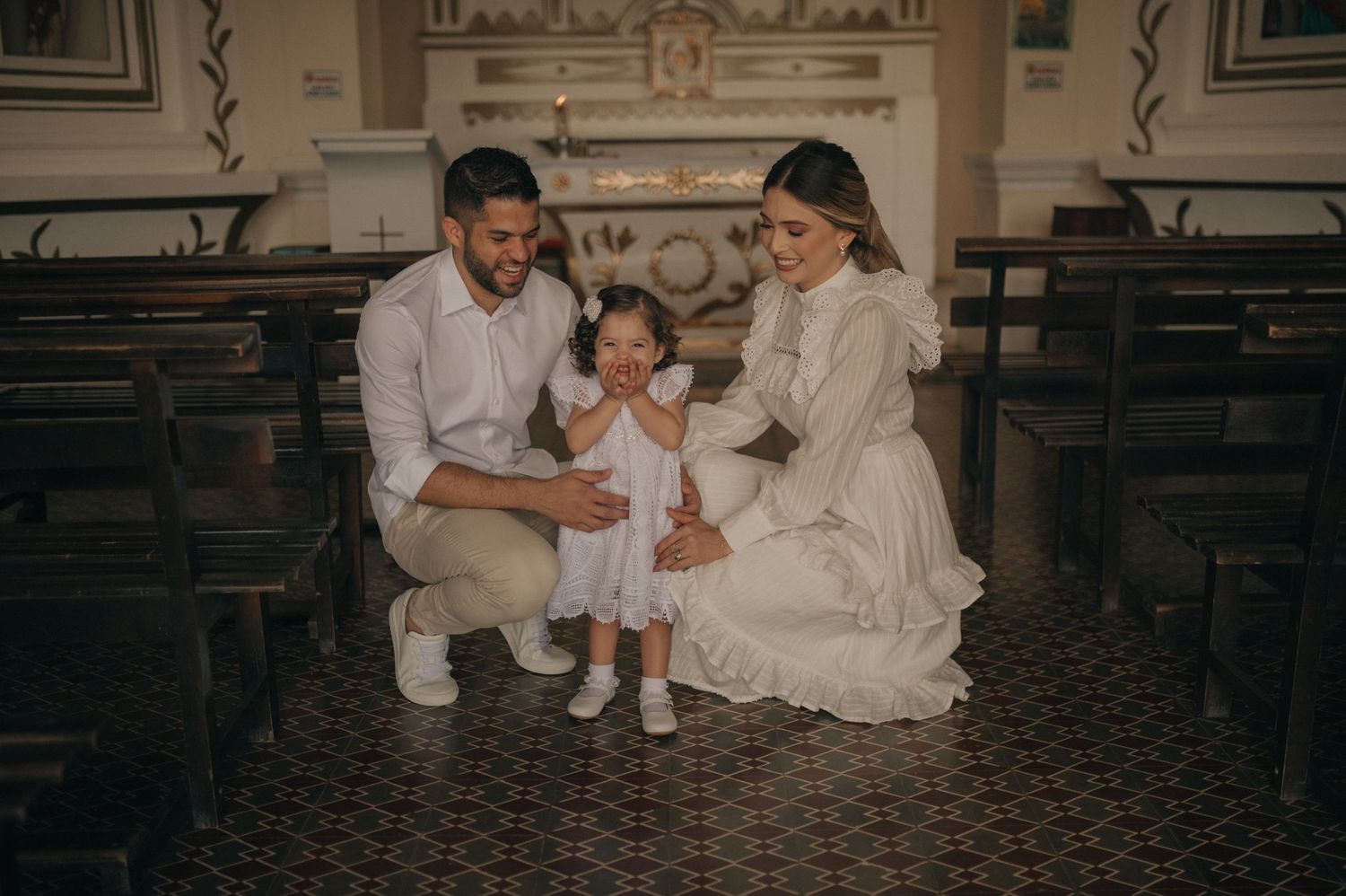 Family sitting together in church pews during a baptism ceremony.