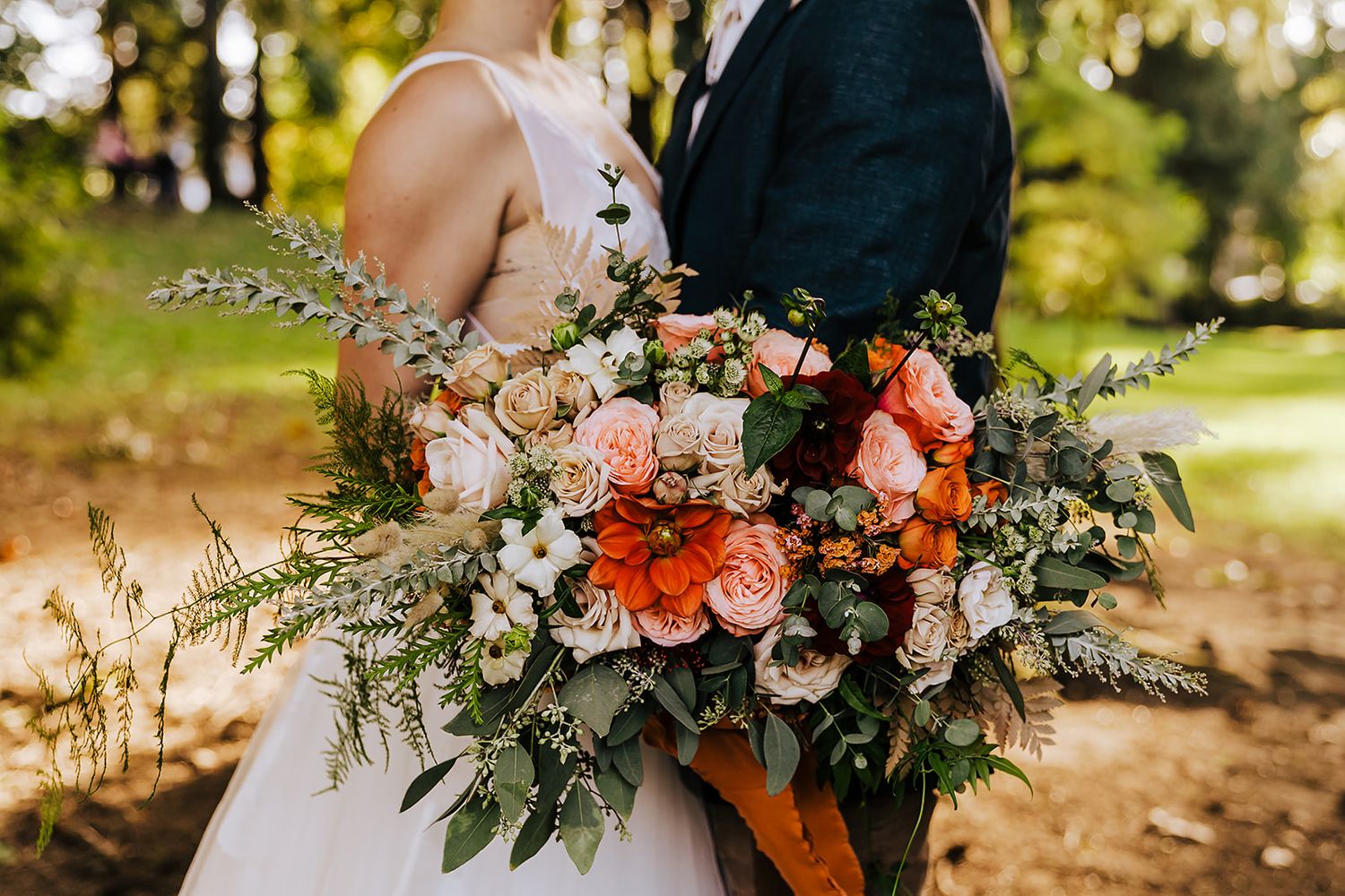 White Female and White Male couple holding bridal bouquet on wedding day. Planned by Wedding Coordinator