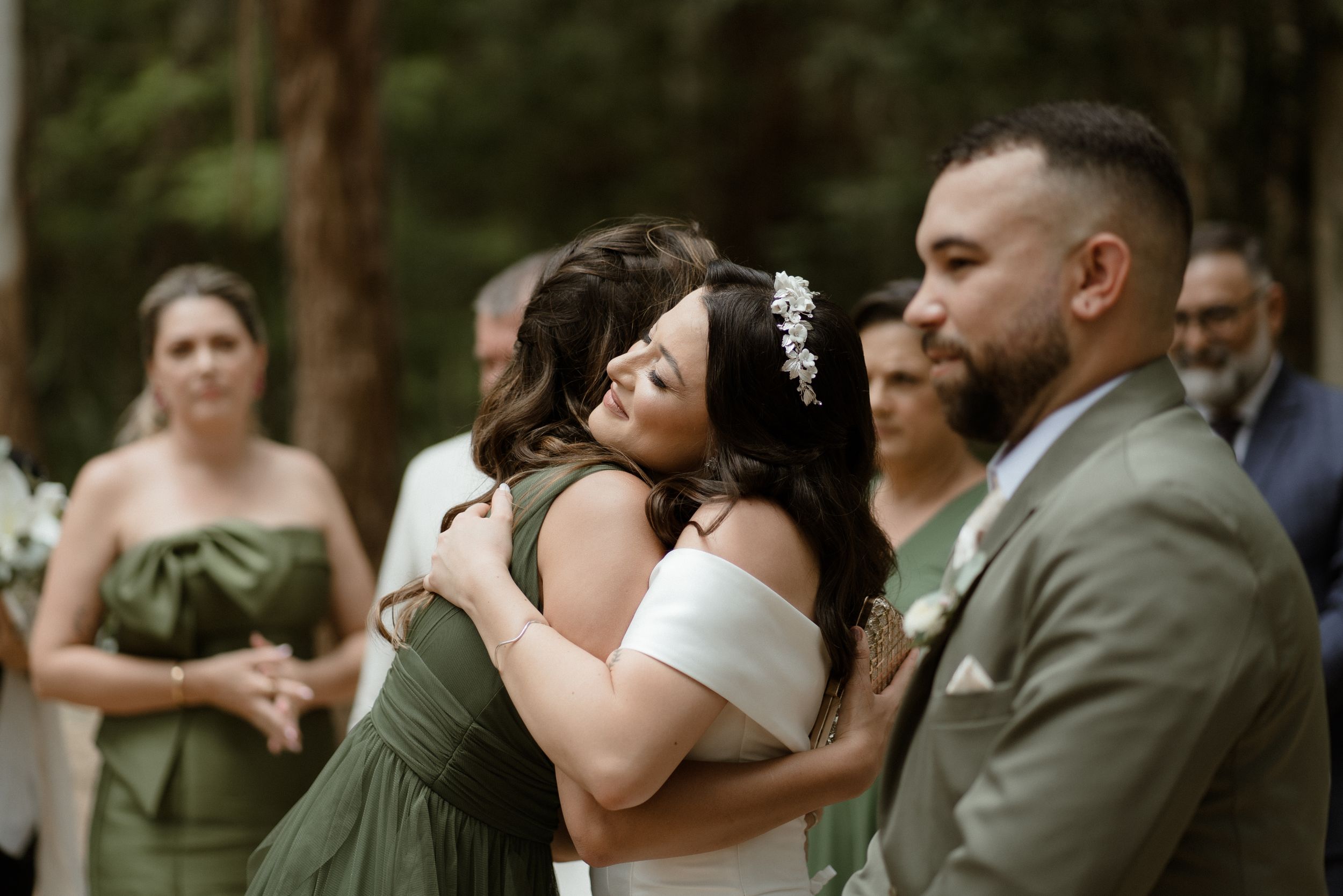 Wedding party celebrating during outdoor forest ceremony.