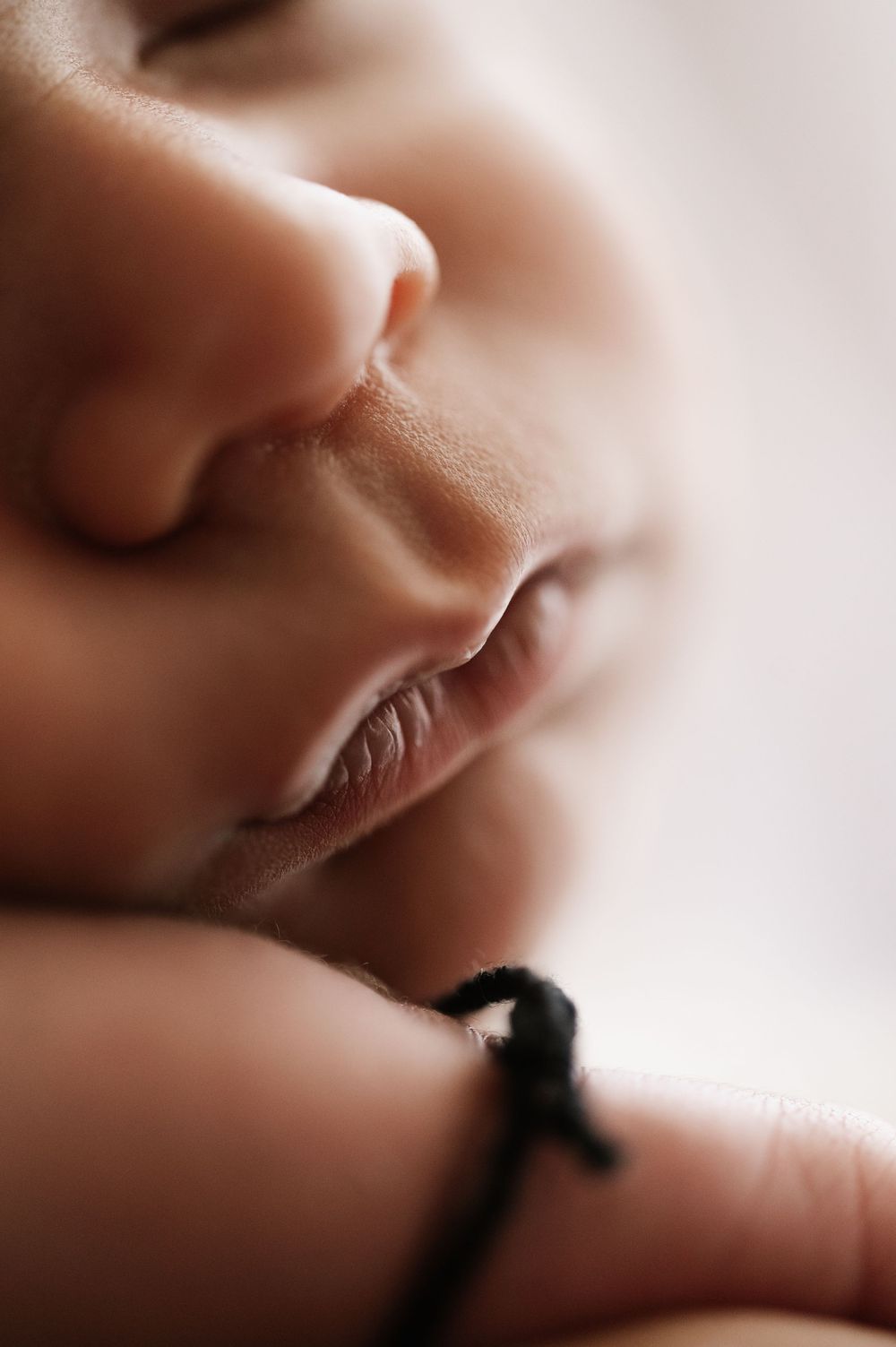 Extreme close-up macro shot of baby's face showing nose and lips in soft focus.