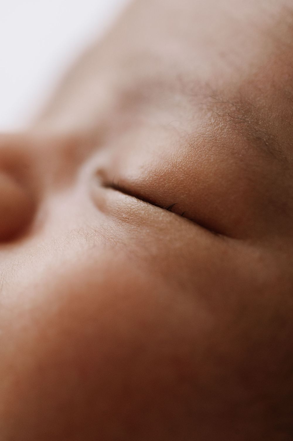 Close-up macro shot of sleeping baby's face showing peaceful expression.