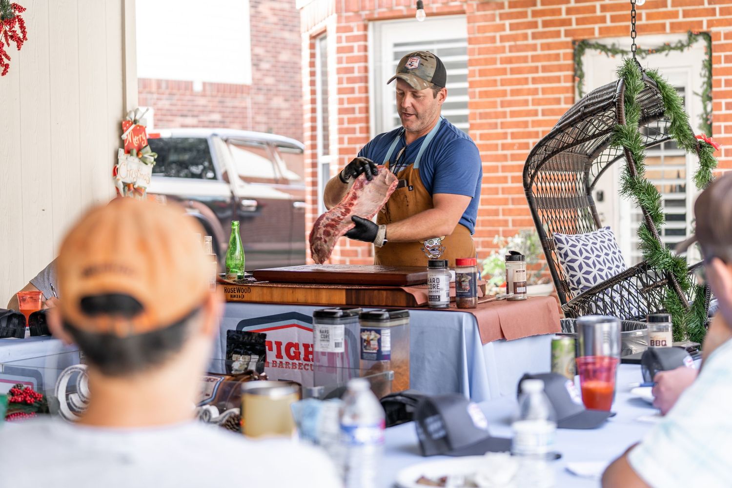 Outdoor cooking demonstration event with chef at serving table.