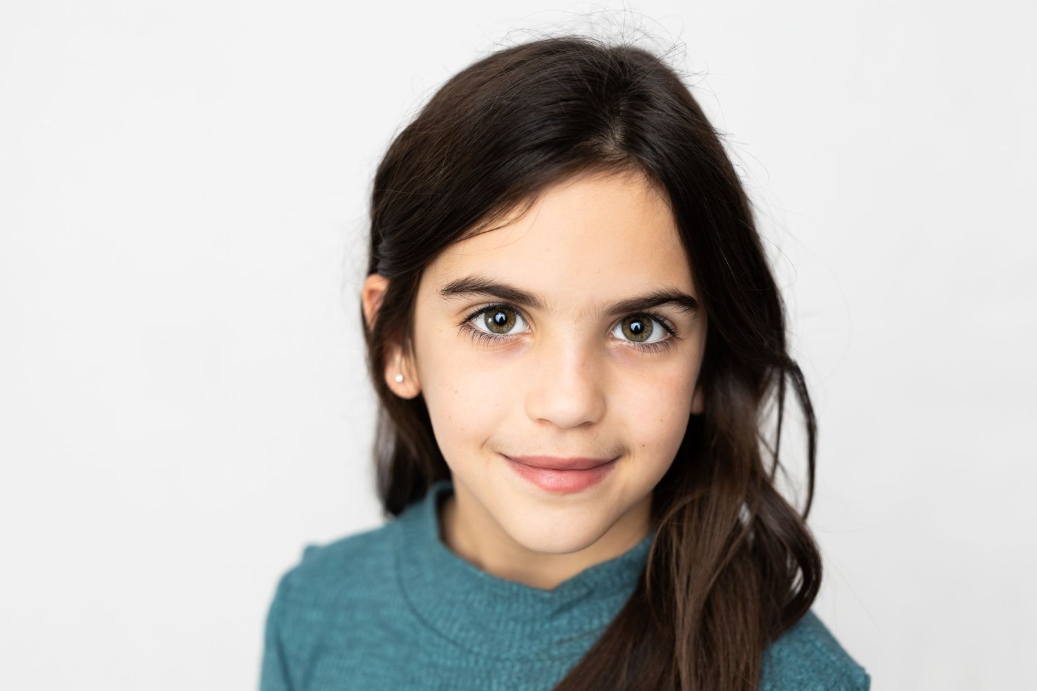 Portrait of a young person in a teal sweater against a white background.