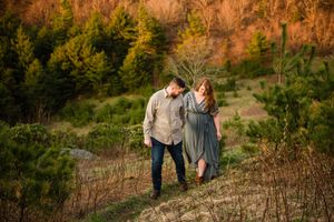 A romantic couple walking together at sunset through a scenic autumn hillside path.