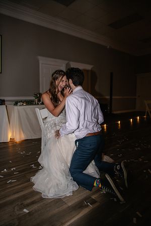 A romantic candlelit dance moment between newlyweds on a wooden floor.