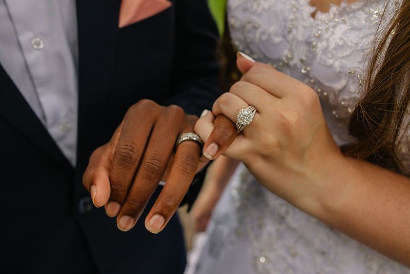 Close-up of wedding rings and hands showing elegant diamond engagement ring.
