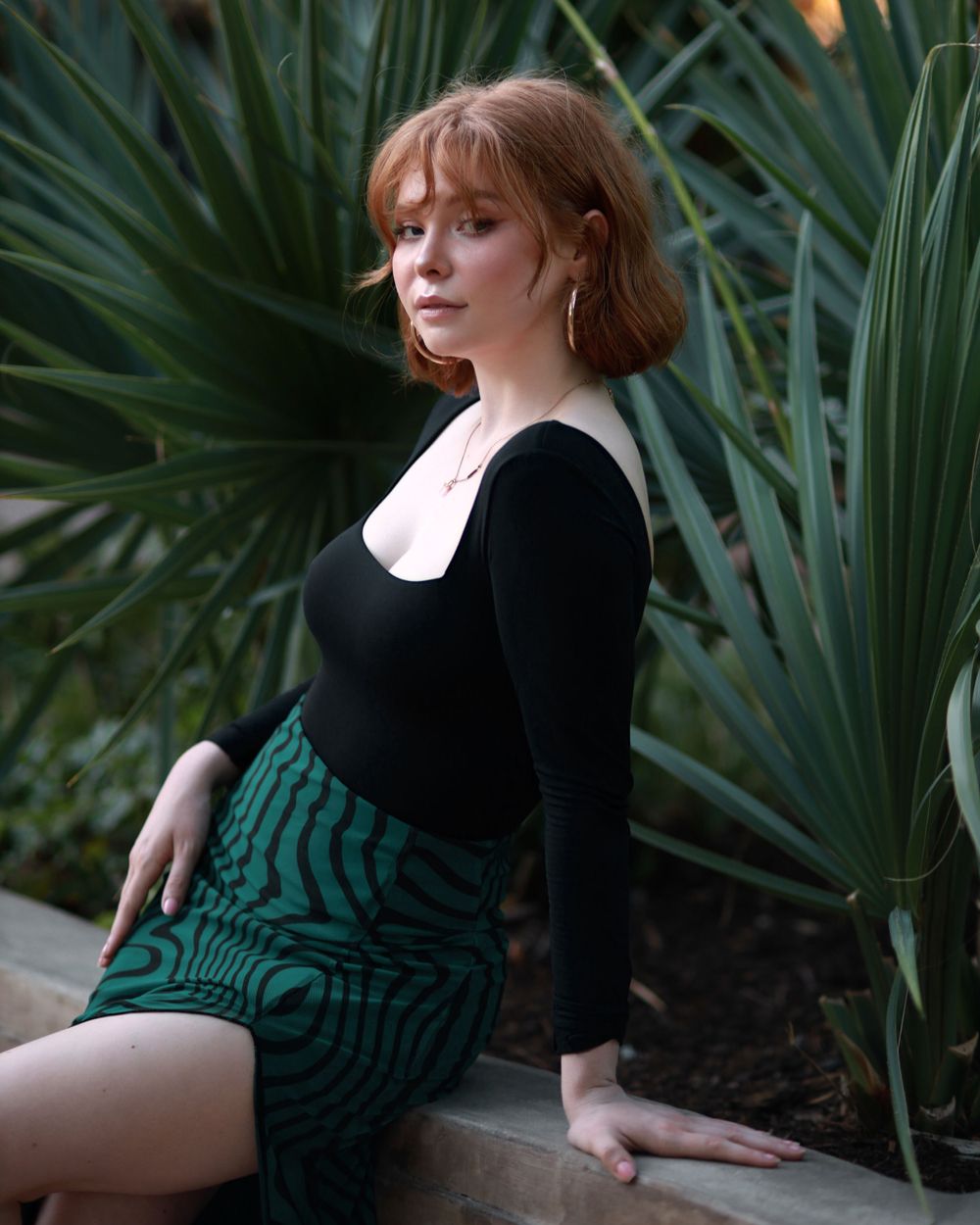 Artistic outdoor portrait series with greenery and moody lighting against palm fronds.
