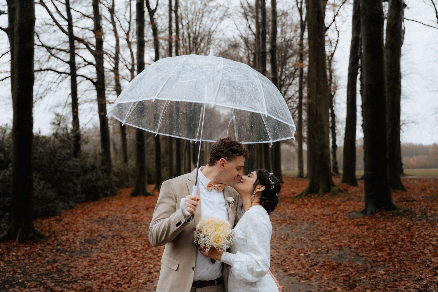 Captured in a magical woodland, a couple in wedding attire shares a tender moment, symbolizing their eternal bond