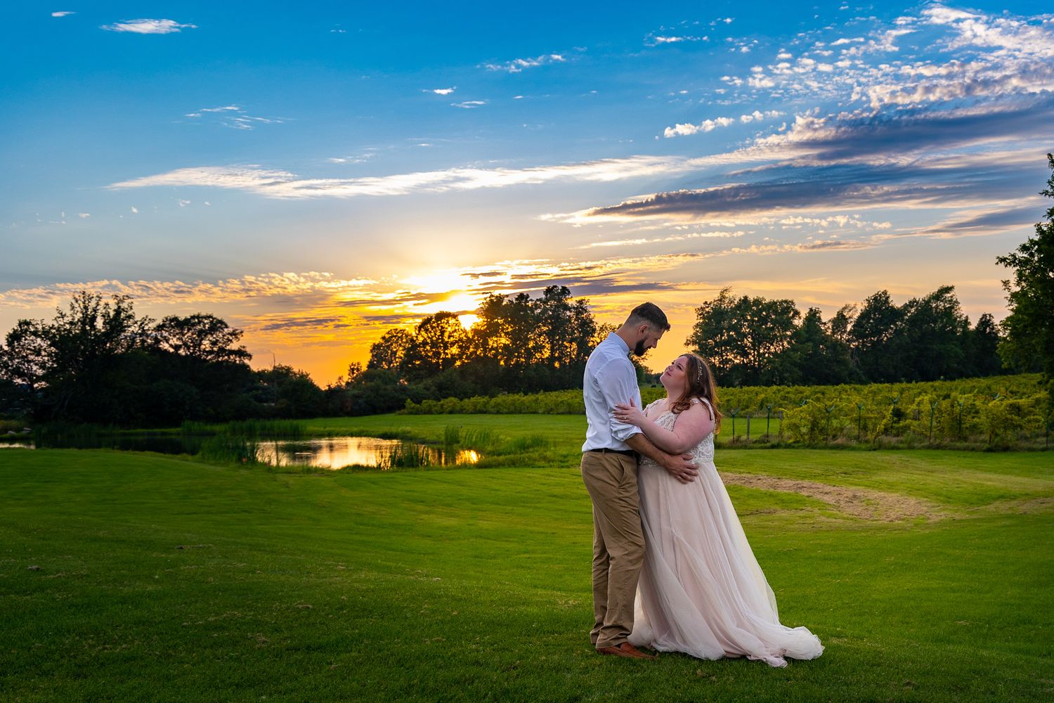 A romantic sunset portrait of a couple on a manicured golf course.