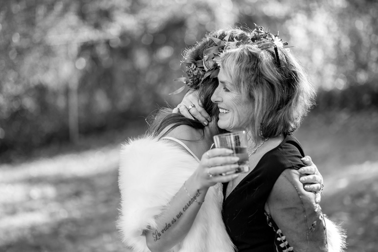 A tender moment captured in black and white during an outdoor celebration.