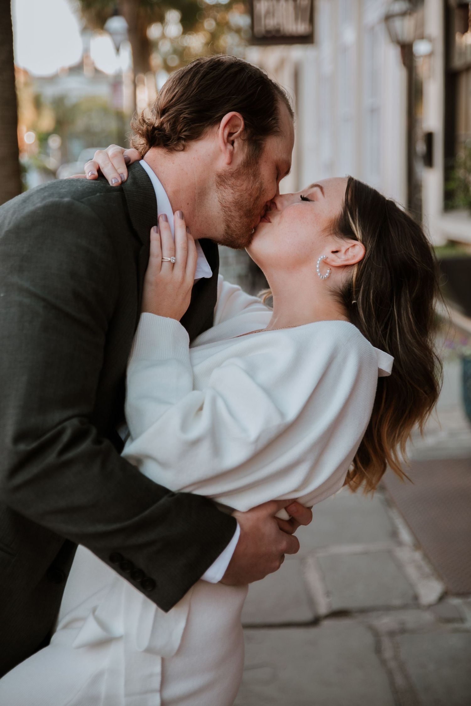 An engaged couple share a kiss