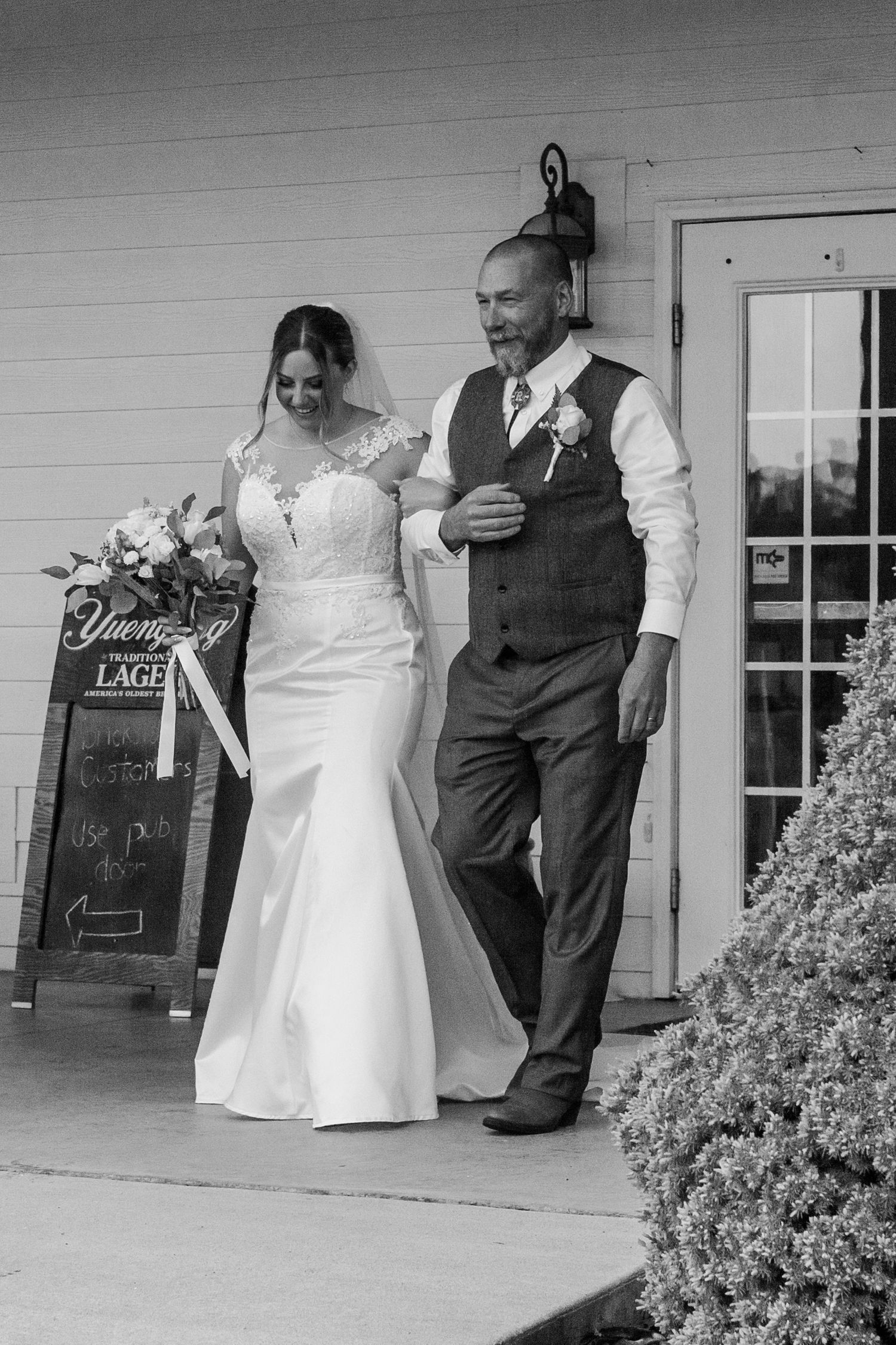 A couple dances together on a white porch with decorative chalkboard signs in black and white.