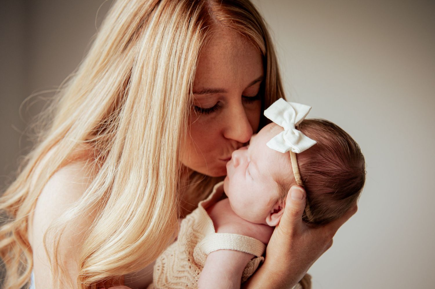 Tender moment between Mother and newborn baby dressed in white with bow.
Altona Family Photographer Melbourne