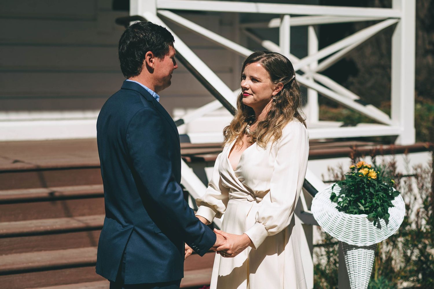 Bride in long sleeve wedding dress looking at groom during ceremony