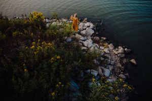 Waterfront scene with rocky outcroppings and yellow flowers along the shoreline.