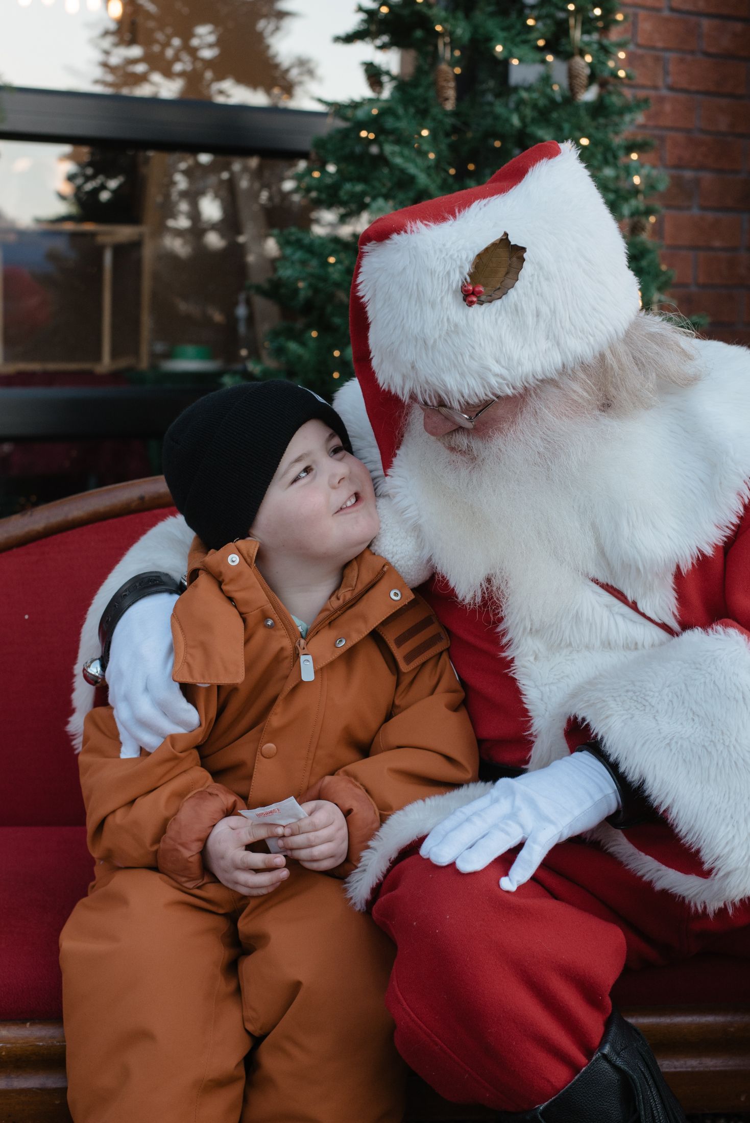 A heartwarming holiday moment captured on a red couch with festive decorations.