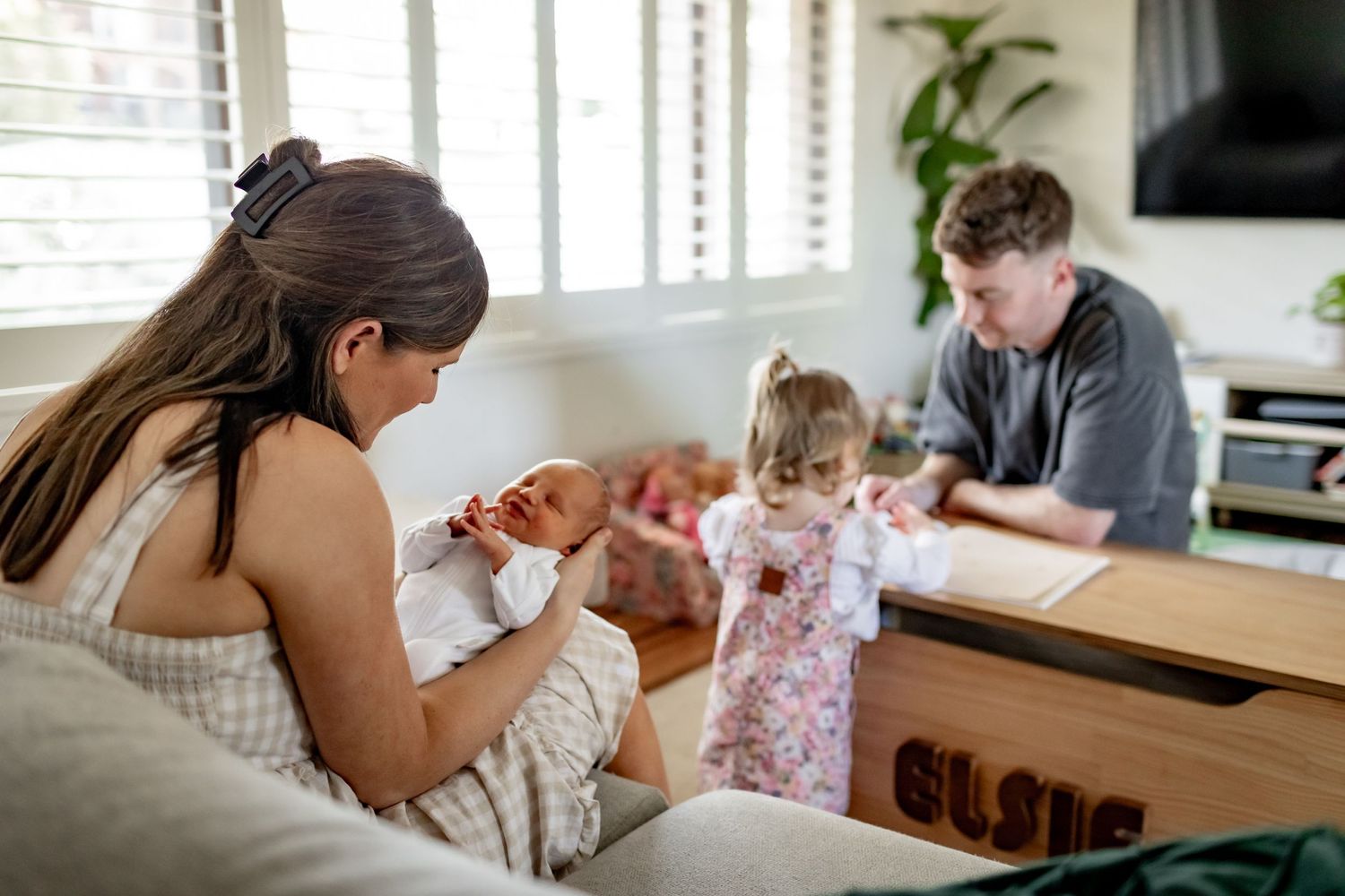 A family spends quality time together in their bright, modern living room with natural light.