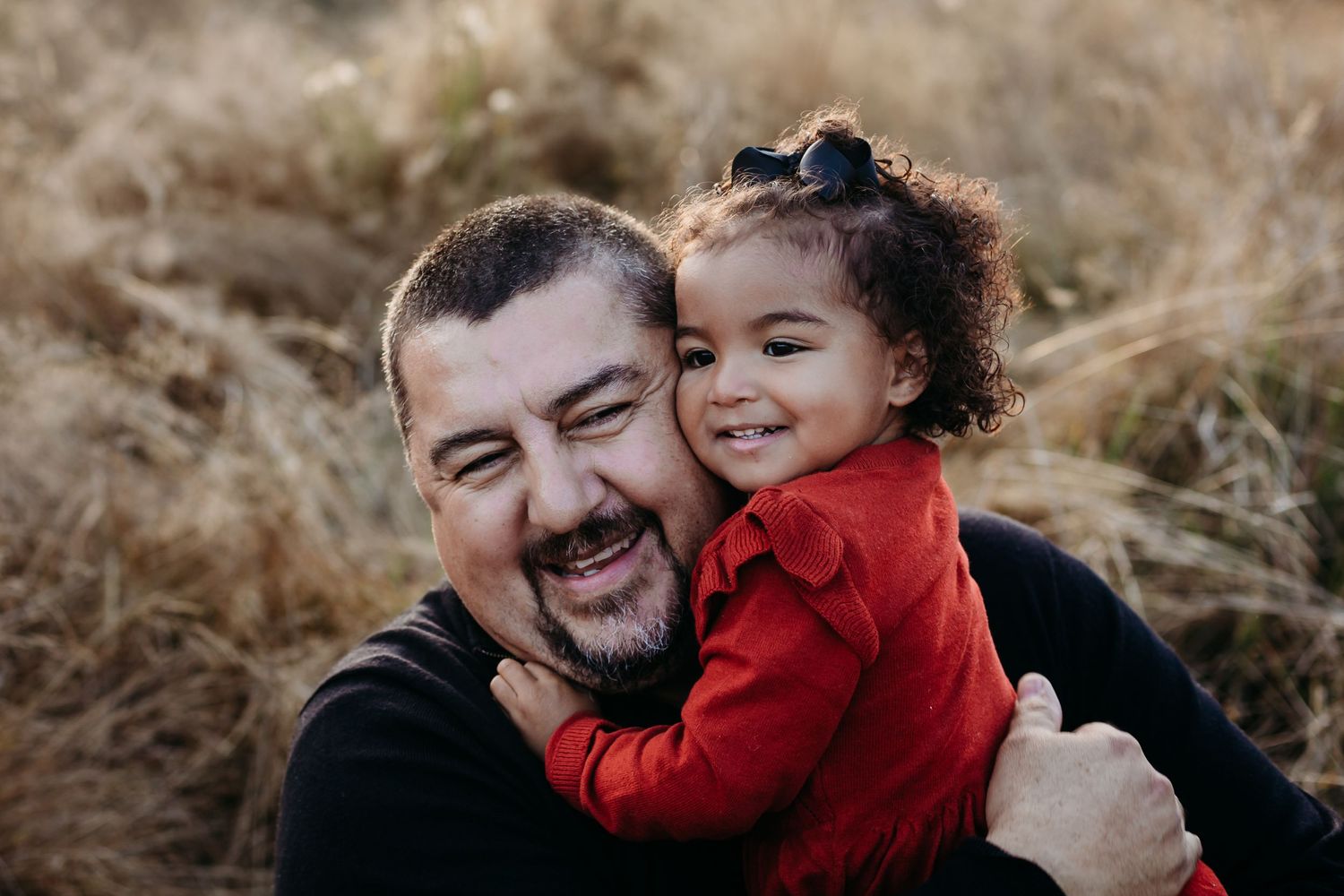 Heartwarming embrace shared against a backdrop of golden autumn grass.