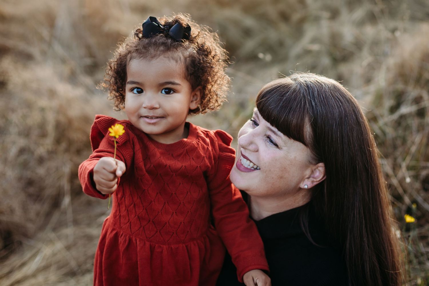 Sweet interaction captured outdoors in a natural setting with warm autumn colors.