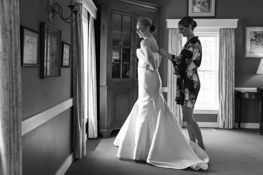Bride adjusting dress before wedding at Chagrin Valley Hunt Club in Ohio.