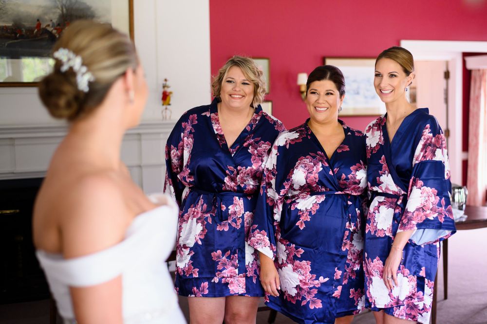 Bridesmaids smiling at bride before wedding at Chagrin Valley Hunt Club in Ohio.