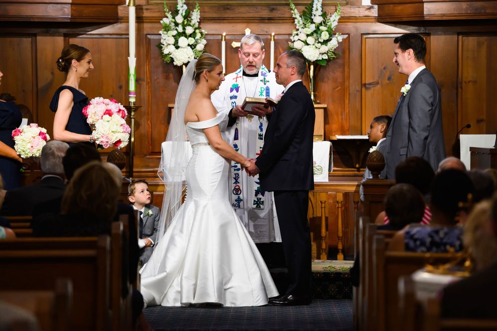 Bride and groom exchange vows during wedding ceremony at St. Huberts Episcopal Church in Kirtland Hills, Ohio.