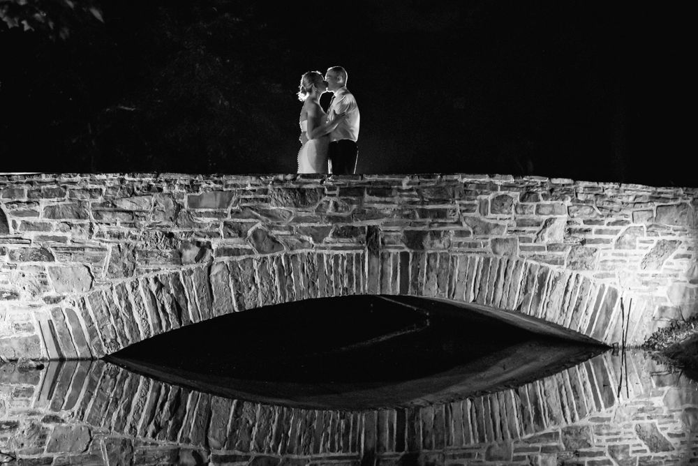 Bride and groom on bridge at night during reception at Chagrin Valley Hunt Club.