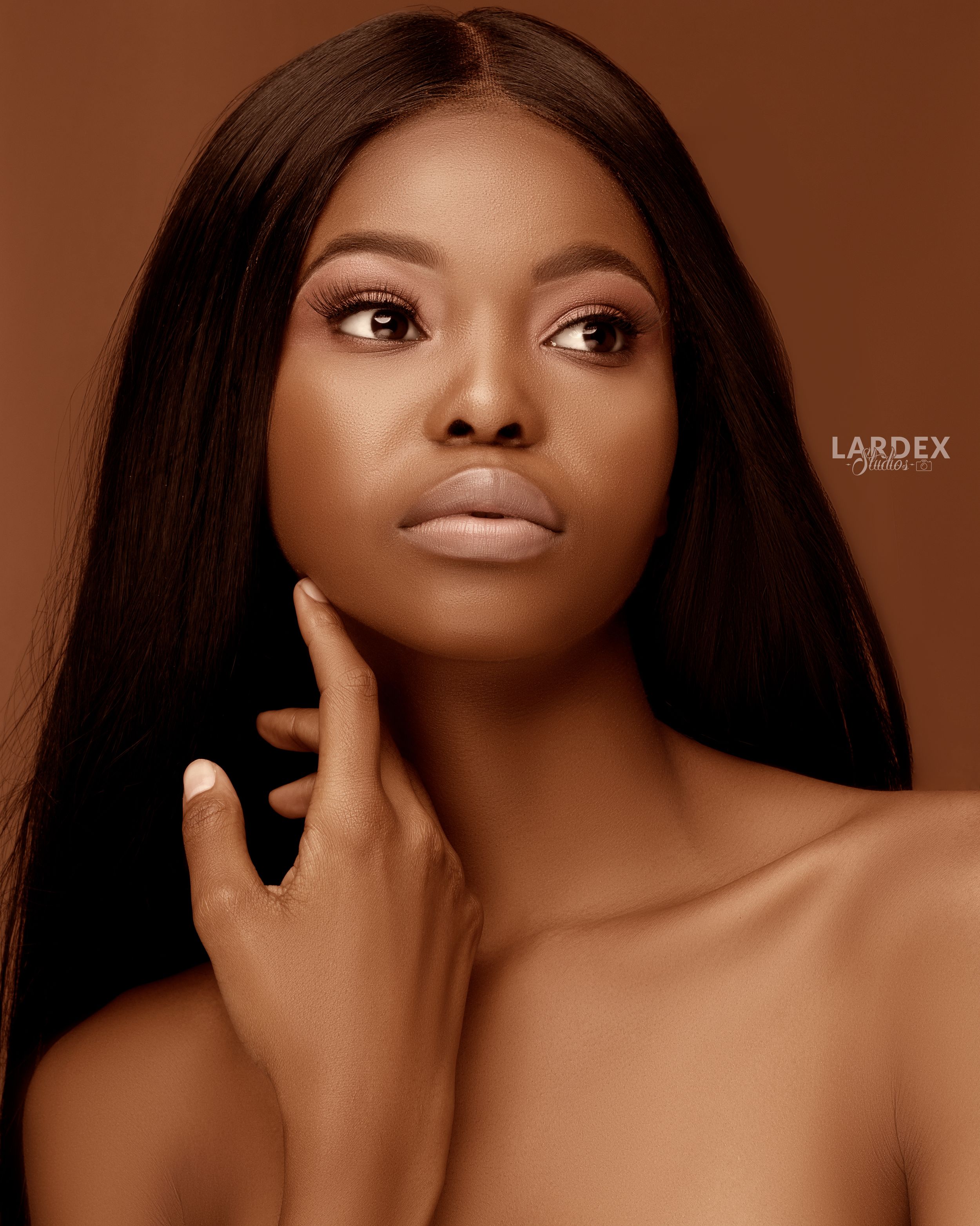 Close-up beauty portrait with smooth skin and flowing dark hair.