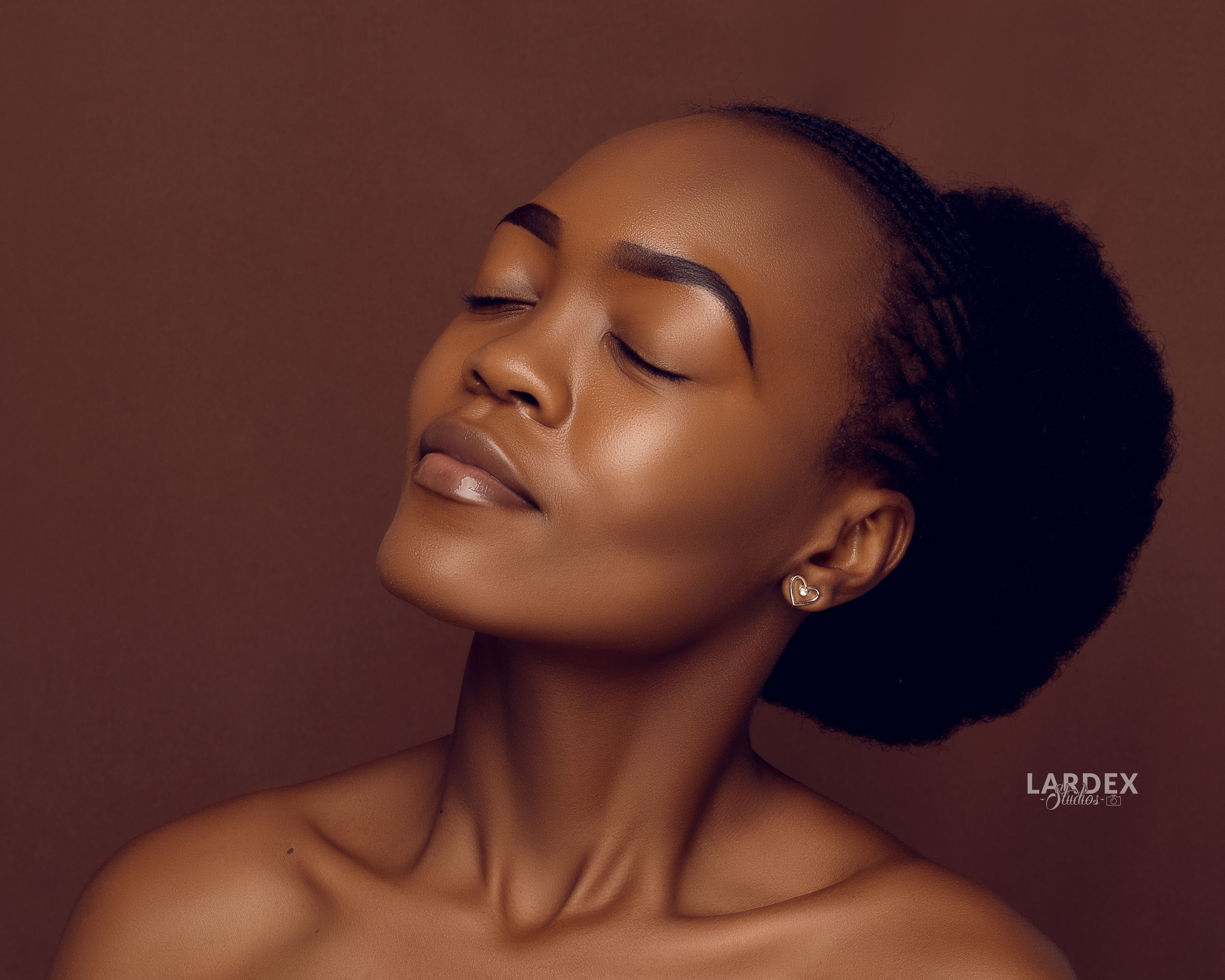 Elegant profile portrait showing radiant skin and natural makeup.
