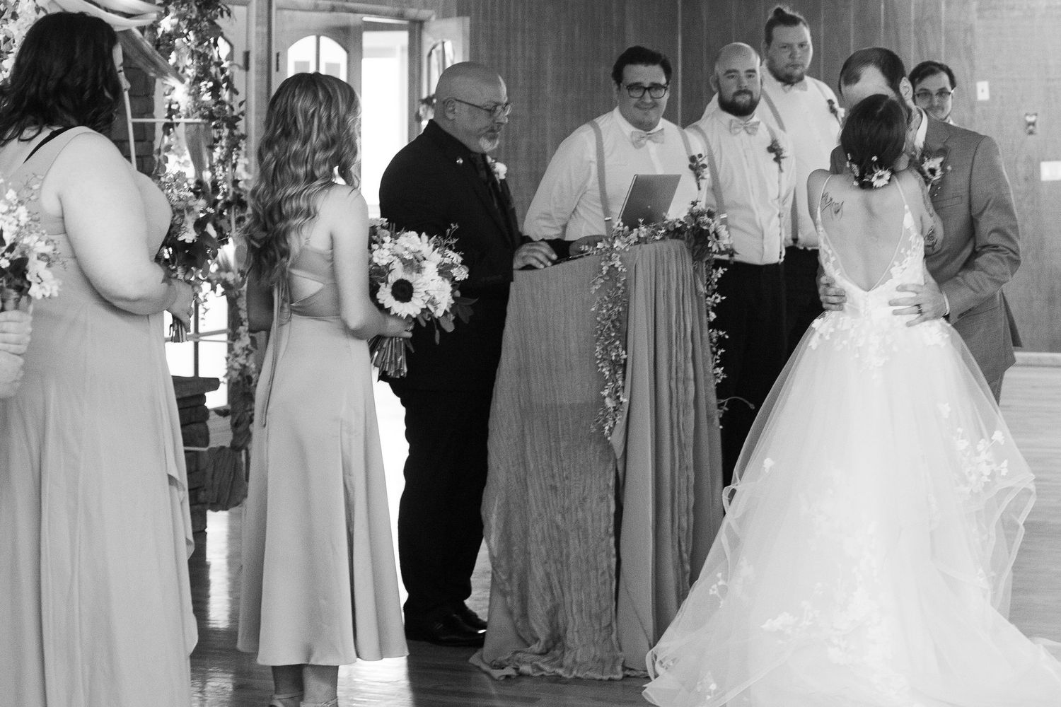 Black and white photo of wedding party members gathered in formal attire.