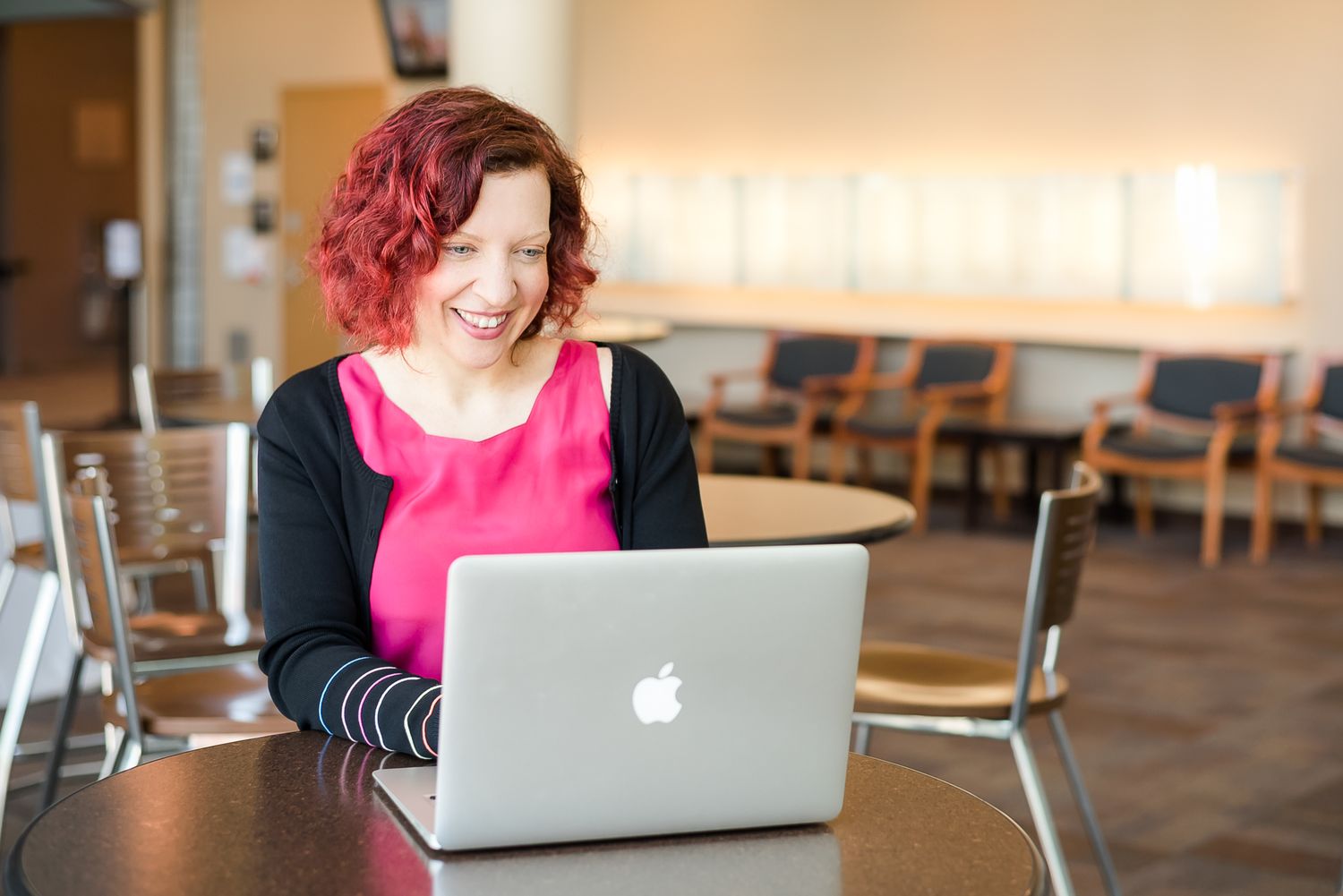 A woman works on her computer sitting in her office building in Maple Ridge, BC.