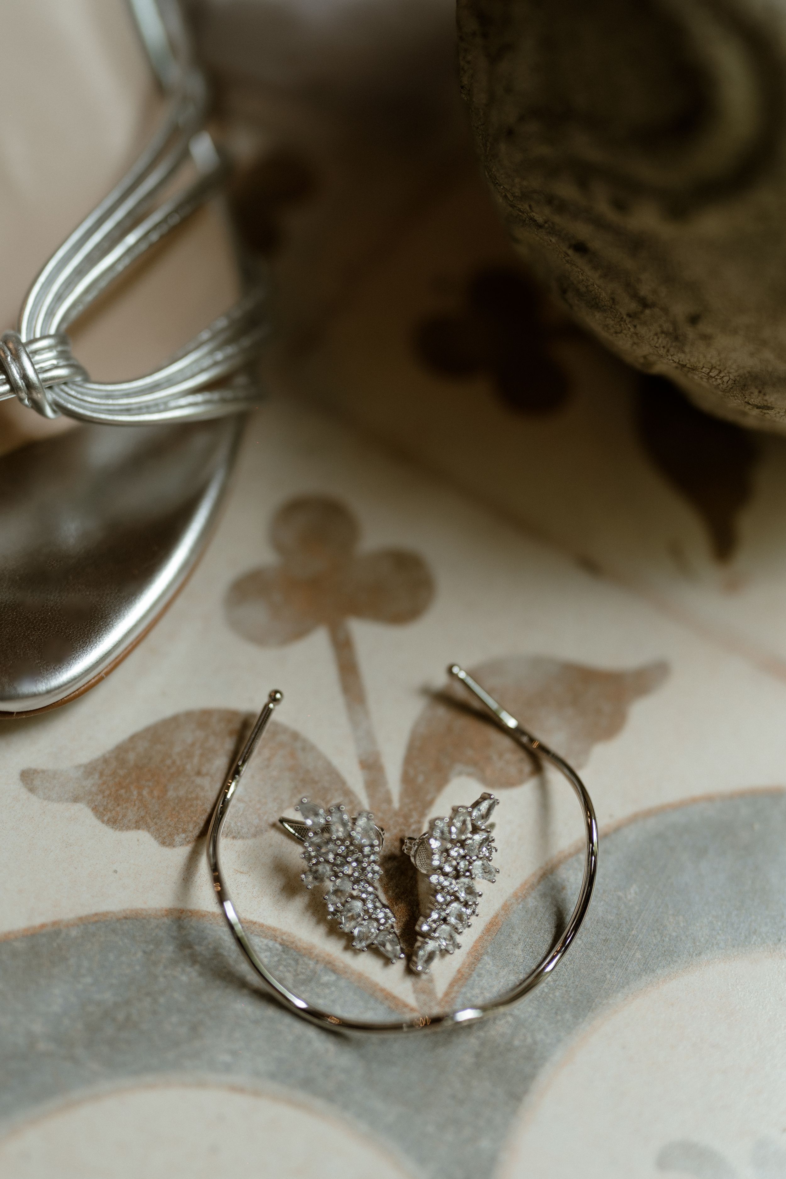 Wedding jewelry and accessories displayed on a patterned surface with delicate details.