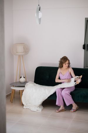 Wedding preparations in a modern room with green velvet sofa and stylish floor lamp.