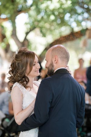 An intimate moment between newlyweds dancing together at their outdoor reception.