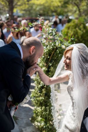 A romantic wedding moment captured in a garden setting with lush greenery.