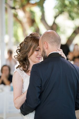 A romantic first dance captured at an outdoor wedding reception under natural light.