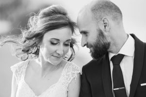 Intimate black and white portrait of newlyweds sharing a tender moment.