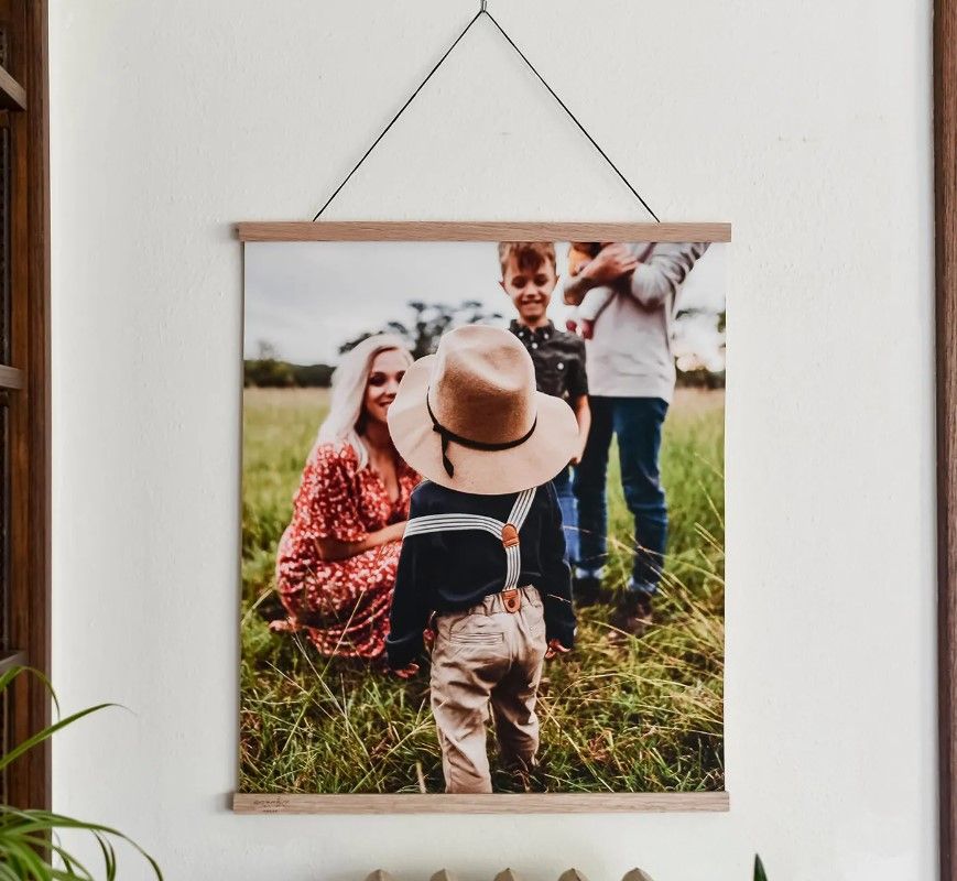 Wooden hanging frame displaying a family photo in a rustic setting.