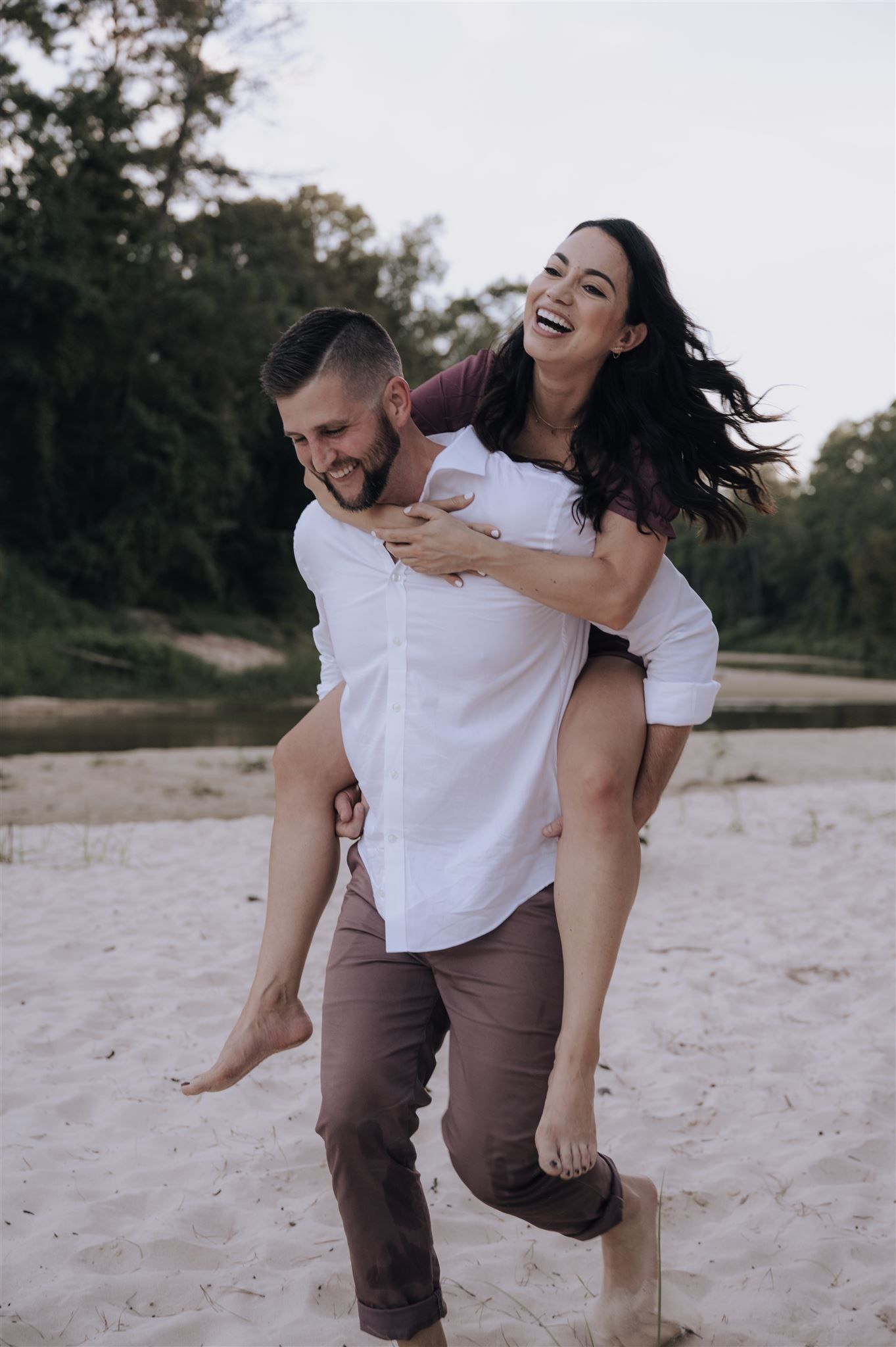 Joyful piggyback ride moment captured on a sandy beach.