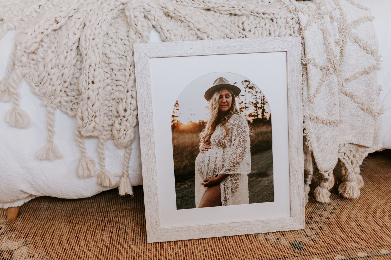 Portrait photograph in white frame displayed on textured beige surface.