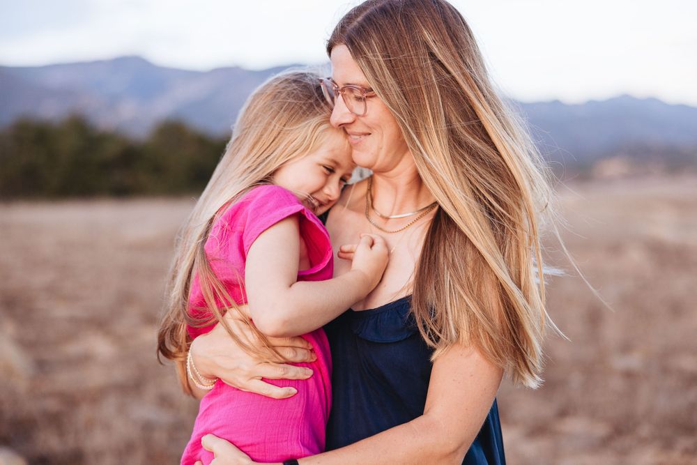 A tender embrace captured in warm light with mountains in the background.