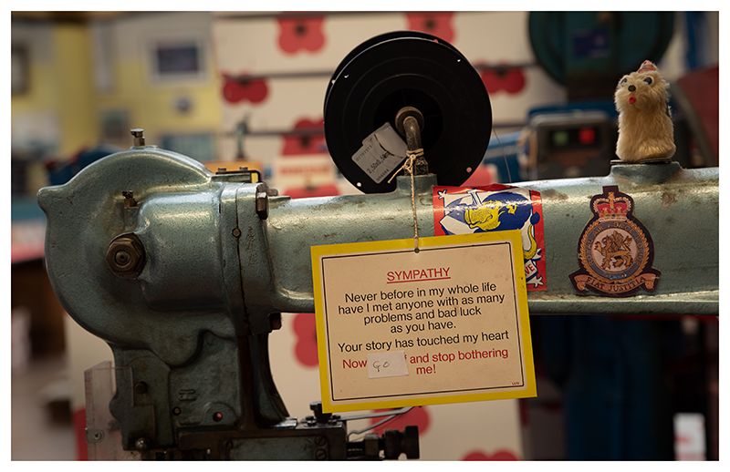 Vintage industrial sewing machine with a warning label attached.