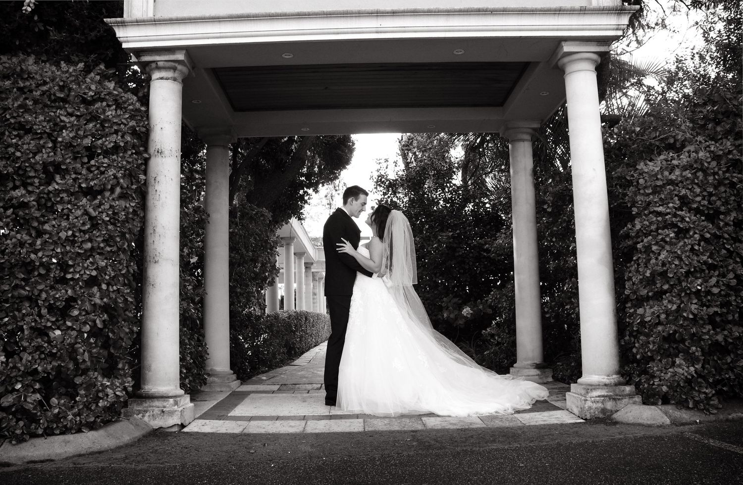 bride and groom looking at eachother in archway of